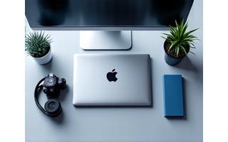 Laptop, professional camera, and various tech gadgets organized on a clean desk