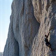 Person rock climbing an outdoor cliff face, representing rock climbing and other outdoor pursuits